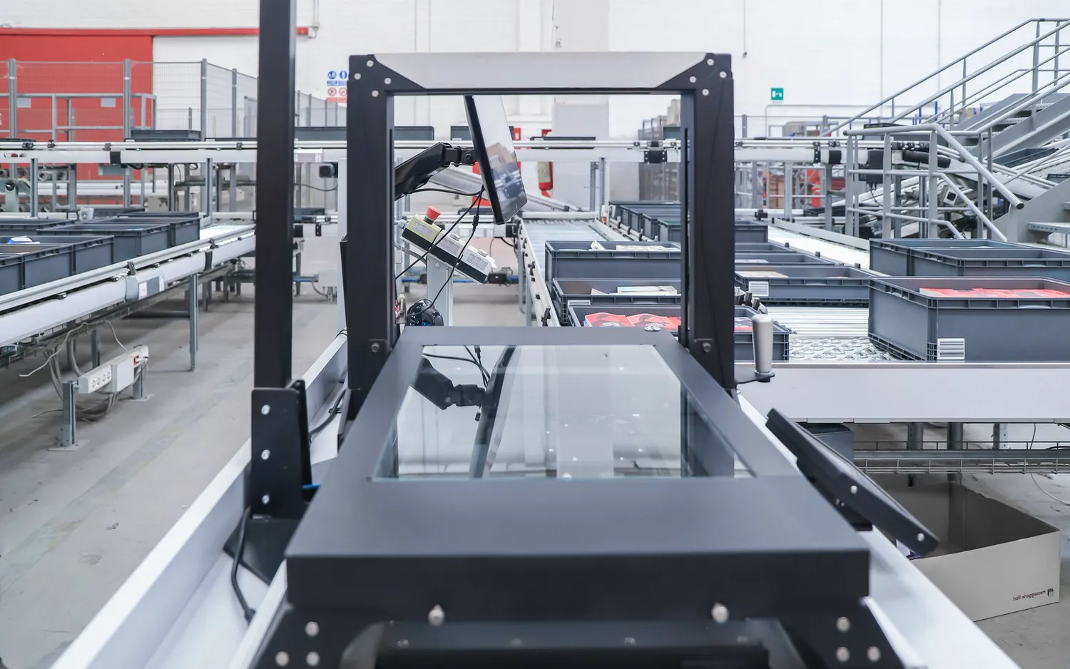 Parcels moving along an automated conveyor sorter inside a warehouse